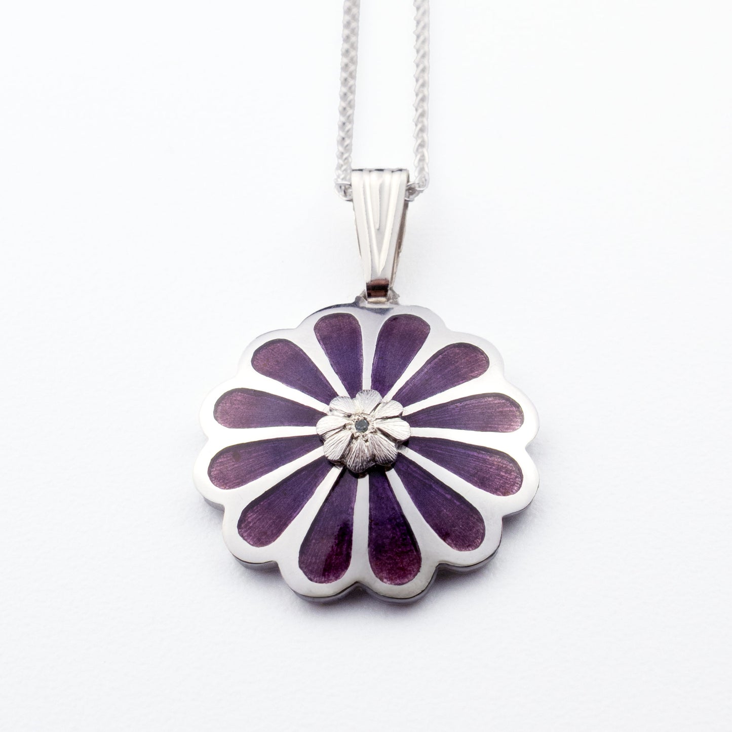 Handmade sterling silver Persian lotus pendant with layered purple vitreous enamel and blue topaz on white background