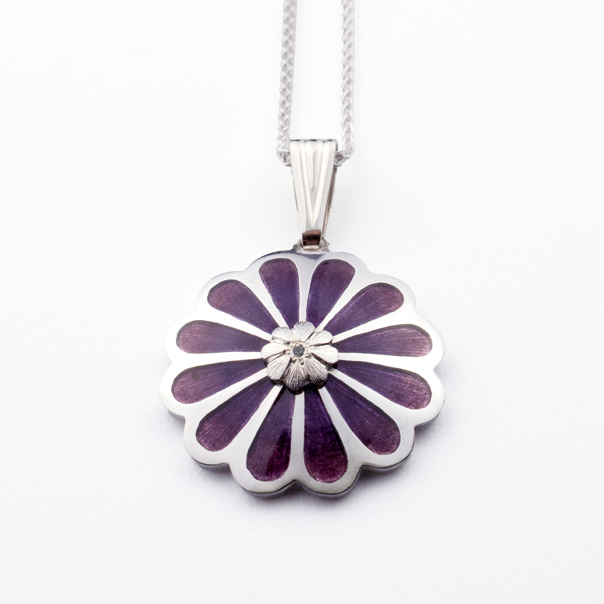 Handmade sterling silver Persian lotus pendant with layered purple vitreous enamel and blue topaz on white background