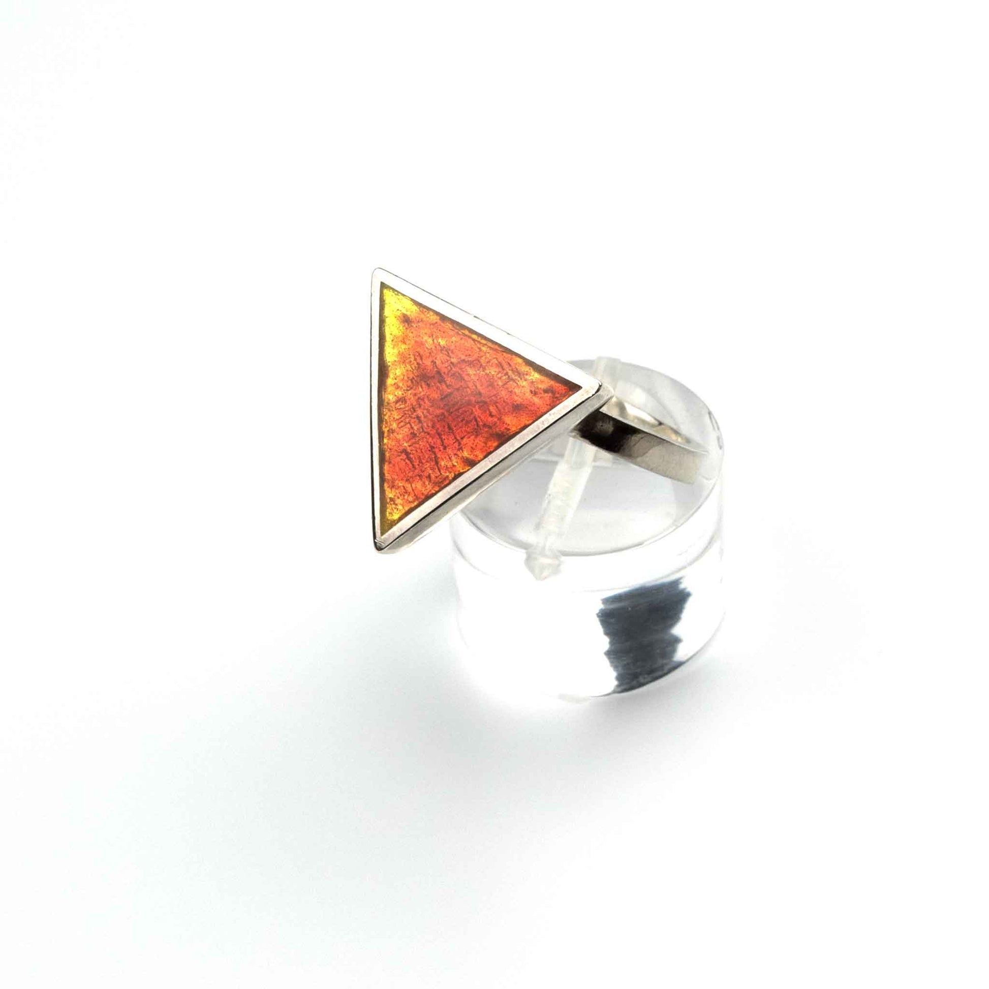 Close-up of Sunset Ember Ring showing luminous bright yellow and fiery orange kiln-fired vitreous enamel on a triangular silver form.