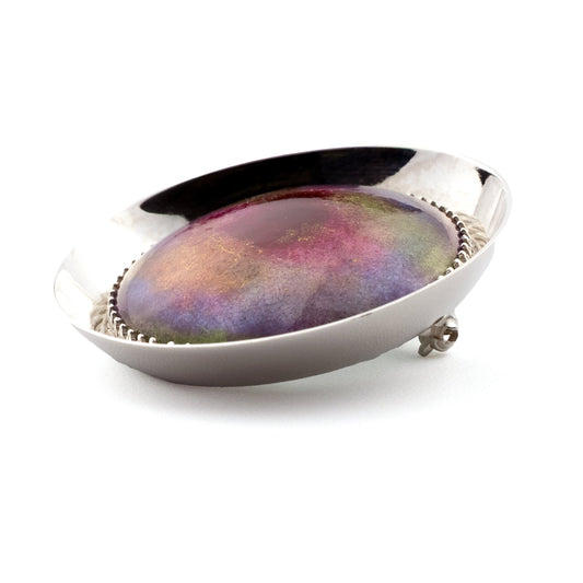 Detail of handmade Supernova brooch showing full vitreous enamel colour range inspired by a dying star